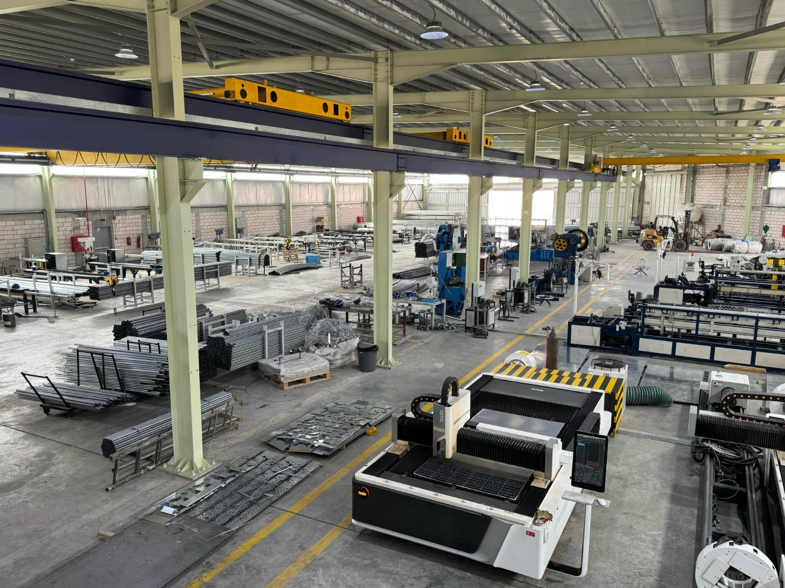 UID fabrication workshop with overhead cranes and laser cutting machines